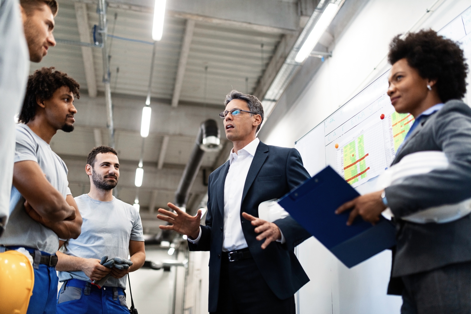 Factory manager holding a meeting and talking to his employees about project plans.